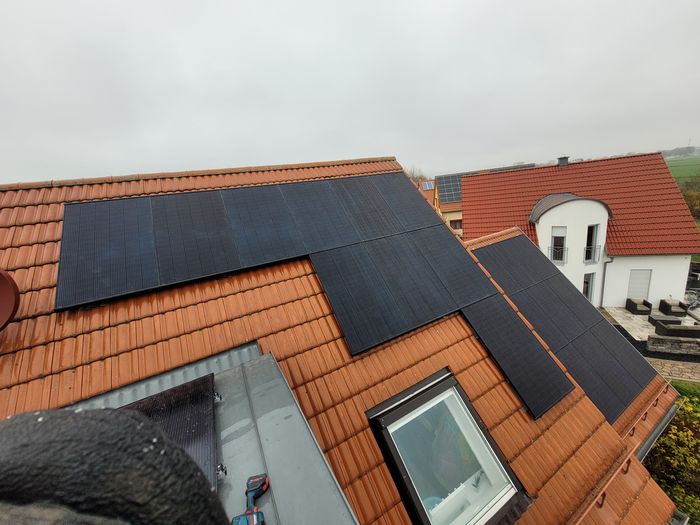 Schwarze Solarmodule auf rotem Ziegeldach